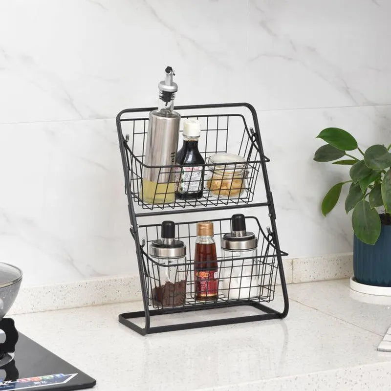 Black two-tier iron art kitchen storage rack with hollowed sides on countertop holding fruit and vegetables