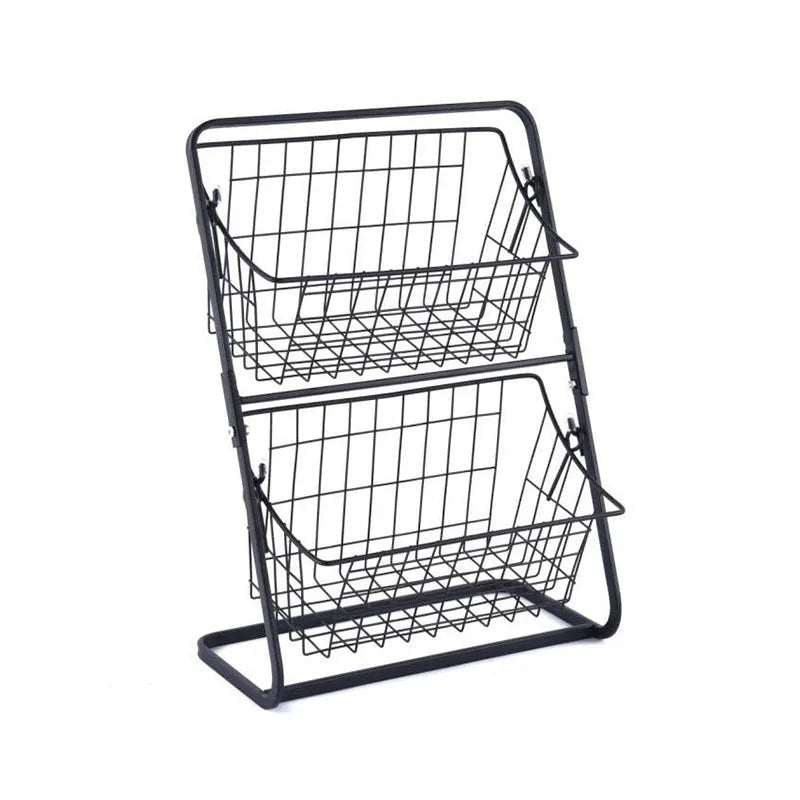 Black two-tier iron art kitchen storage rack with hollowed sides on countertop holding fruit and vegetables
