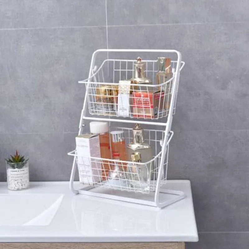 Black two-tier iron art kitchen storage rack with hollowed sides on countertop holding fruit and vegetables