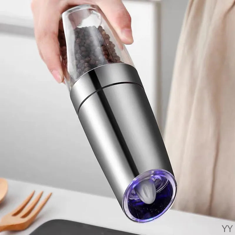 Electric gravity pepper grinder with adjustable coarseness and blue LED light in black ABS finish on wooden table