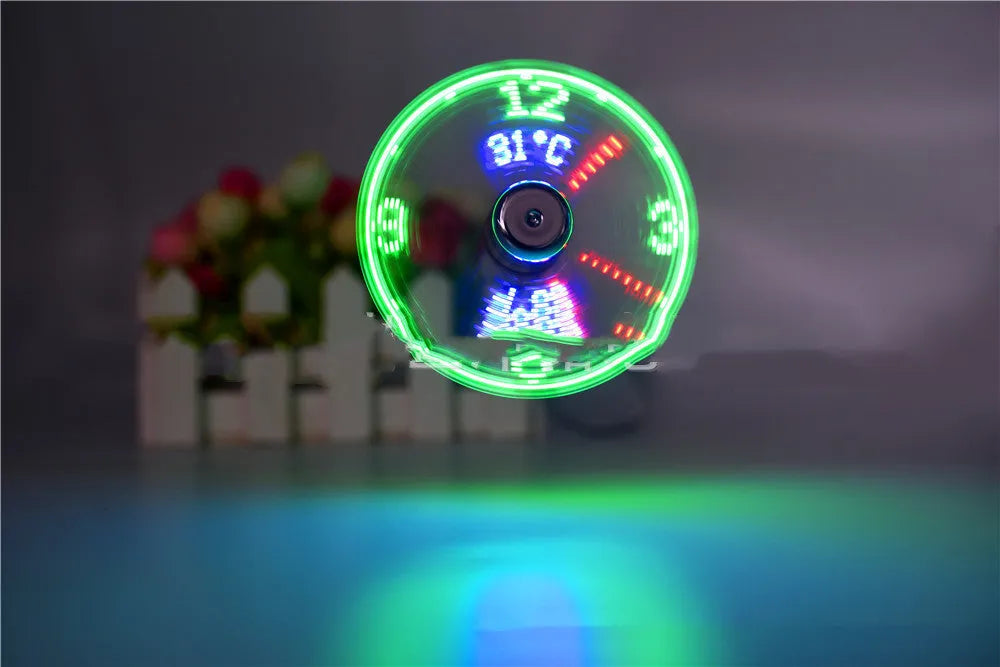 USB clock temperature fan with LED display, soft plastic blades, and flexible silver metal neck on a desk