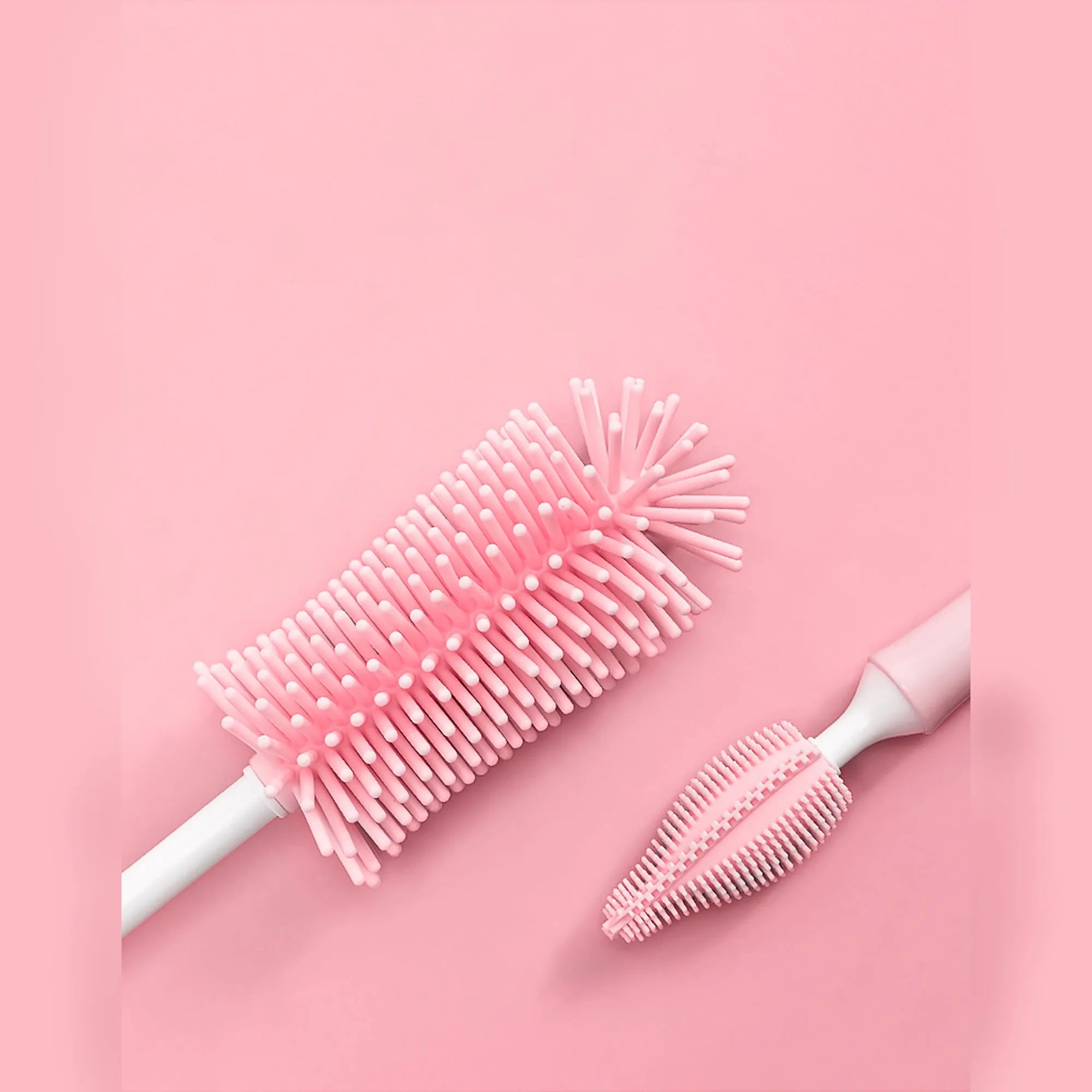 Three-piece silicone baby bottle brush set in pink, blue, and yellow with straw cleaning tool