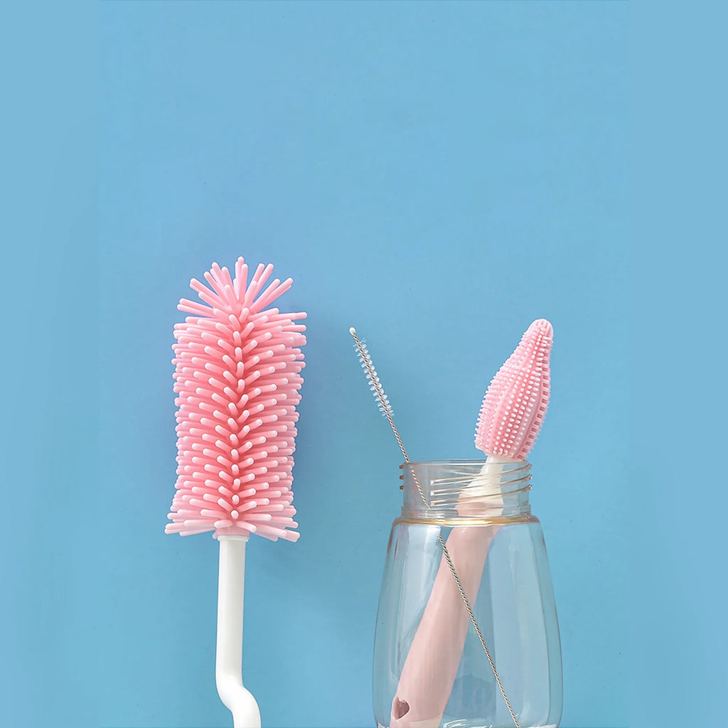 Three-piece silicone baby bottle brush set in pink, blue, and yellow with straw cleaning tool