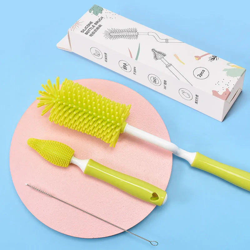 Three-piece silicone baby bottle brush set in pink, blue, and yellow with straw cleaning tool