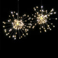 Solar-powered LED firework explosion light hanging outdoors with warm white meteor shower effect.