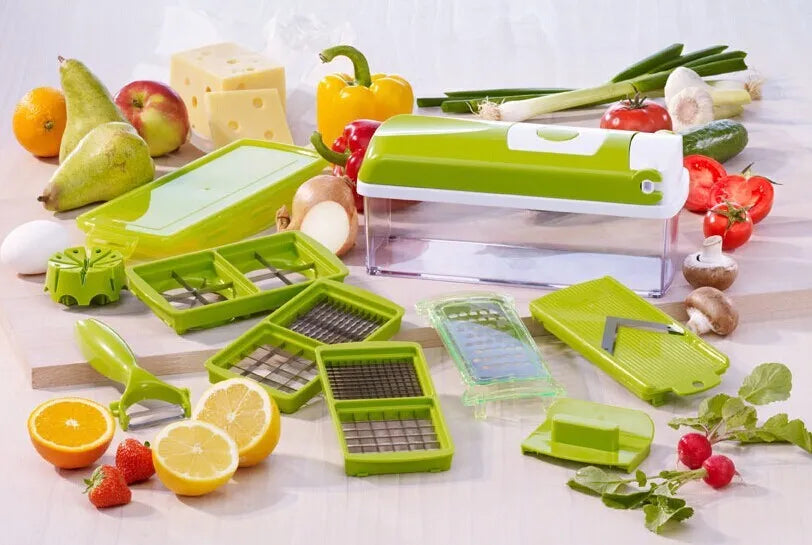 Green multifunctional vegetable chopper with handle, grater, and stainless steel blades on a chopping board
