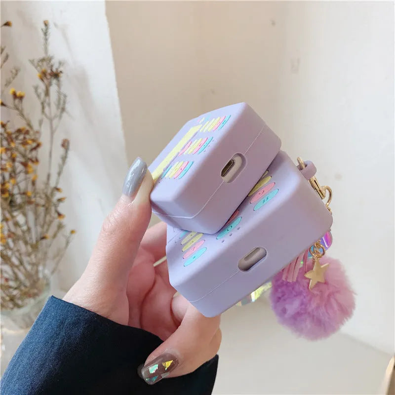 Purple silicone clamshell case for Apple AirPods Pro and AirPods 1 2 with a fur ball pendant.