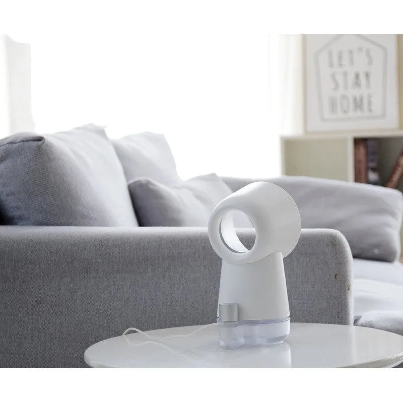 White round desktop humidifier with leafless fan vent, ultrasonic cool mist fog outlet, USB cable, and warm night light glowing