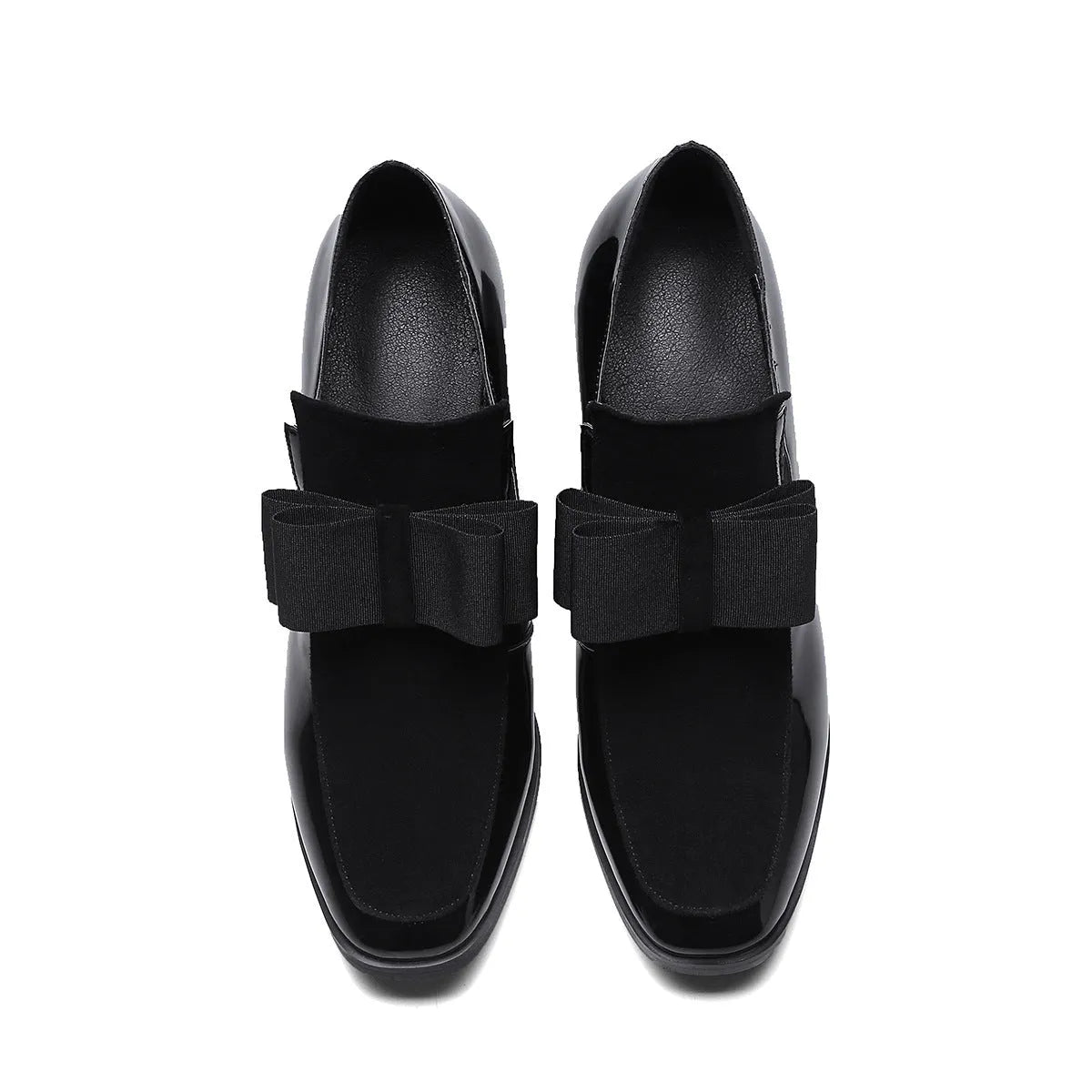 Black patent leather women's high heels with a thick super high heel and square toe on a plain background.