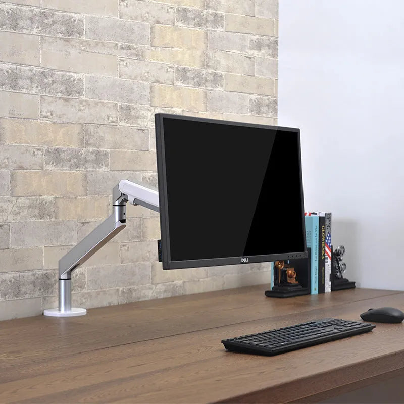Adjustable lifting computer monitor stand in silver on a desk with a screen placed on top