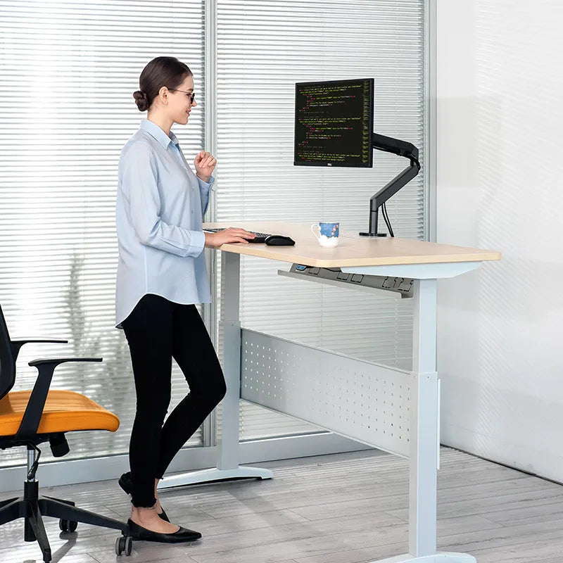 Adjustable lifting computer monitor stand in silver on a desk with a screen placed on top