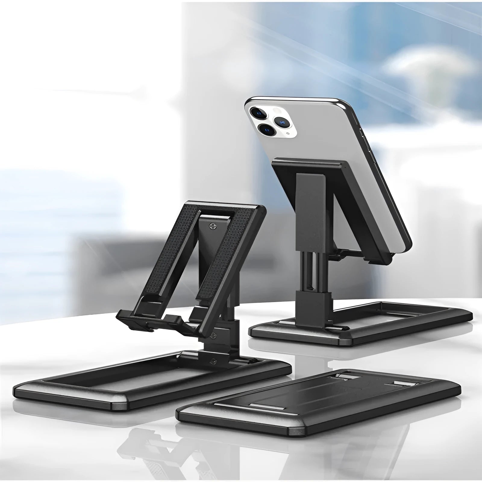 Retractable folding mobile phone desktop stand in black on a desk