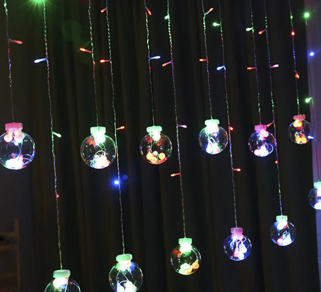 2.5 metre 108 LED curtain light string in warm white mode on a dark background showing plastic shell and plug-in cable