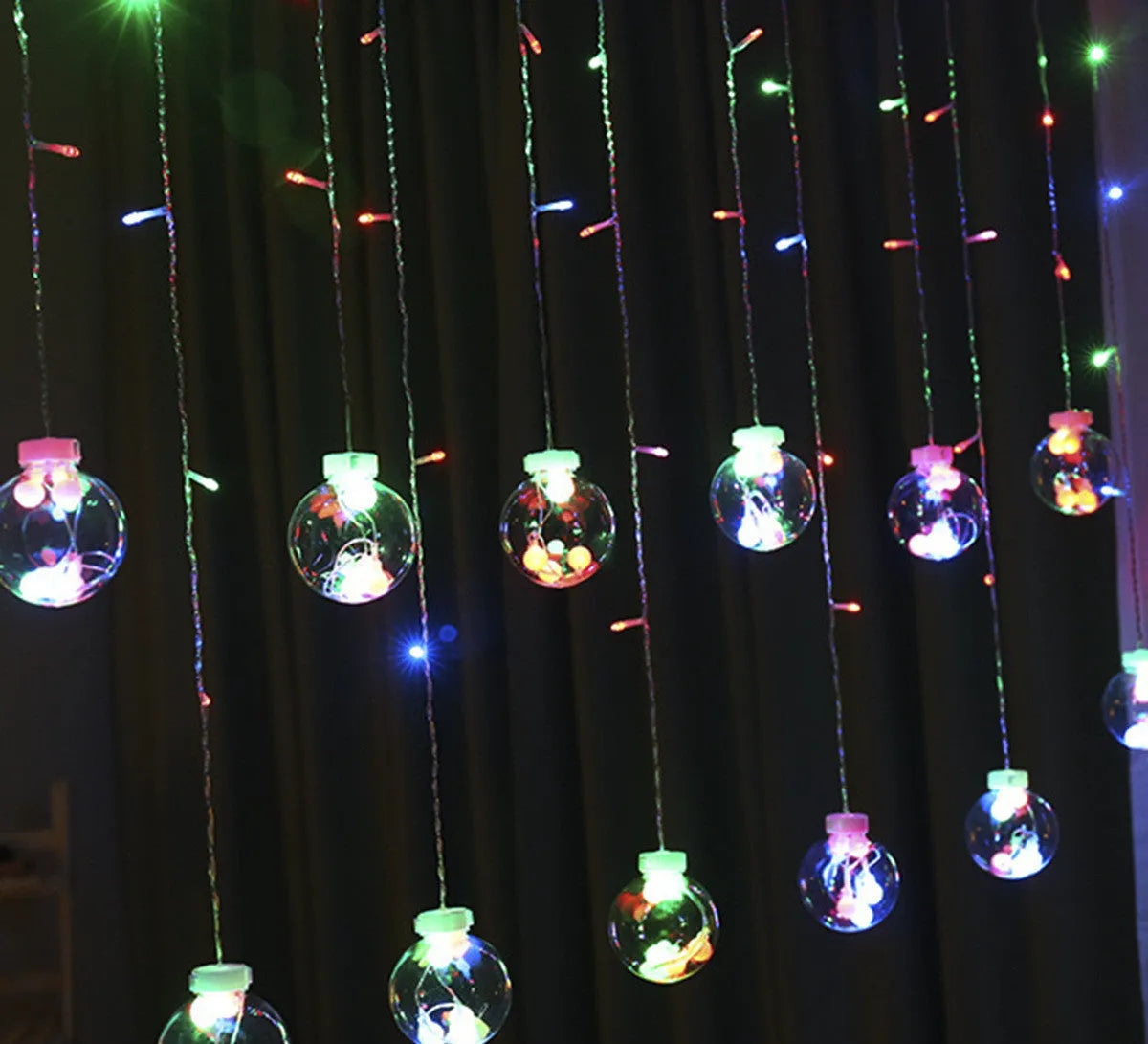 2.5 metre 108 LED curtain light string in warm white mode on a dark background showing plastic shell and plug-in cable