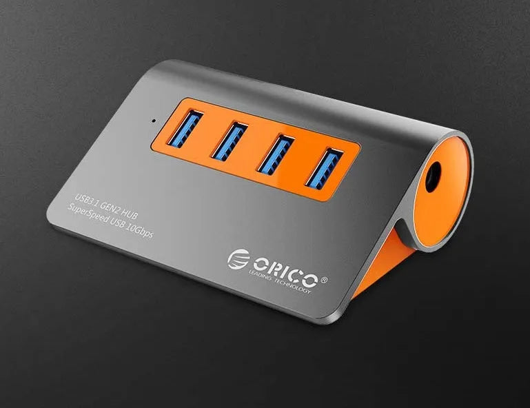 Dark grey aluminium USB hub with four USB 3.1 ports, orange accent, and detachable 100cm cable