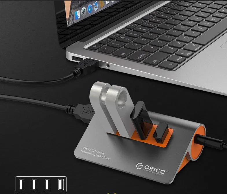 Dark grey aluminium USB hub with four USB 3.1 ports, orange accent, and detachable 100cm cable