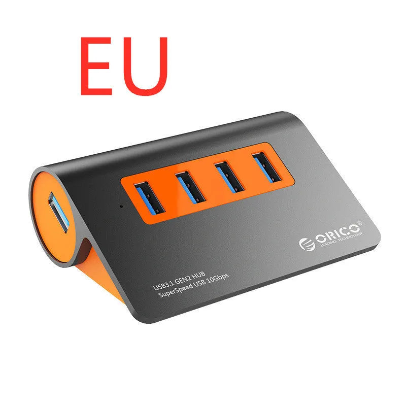 Dark grey aluminium USB hub with four USB 3.1 ports, orange accent, and detachable 100cm cable
