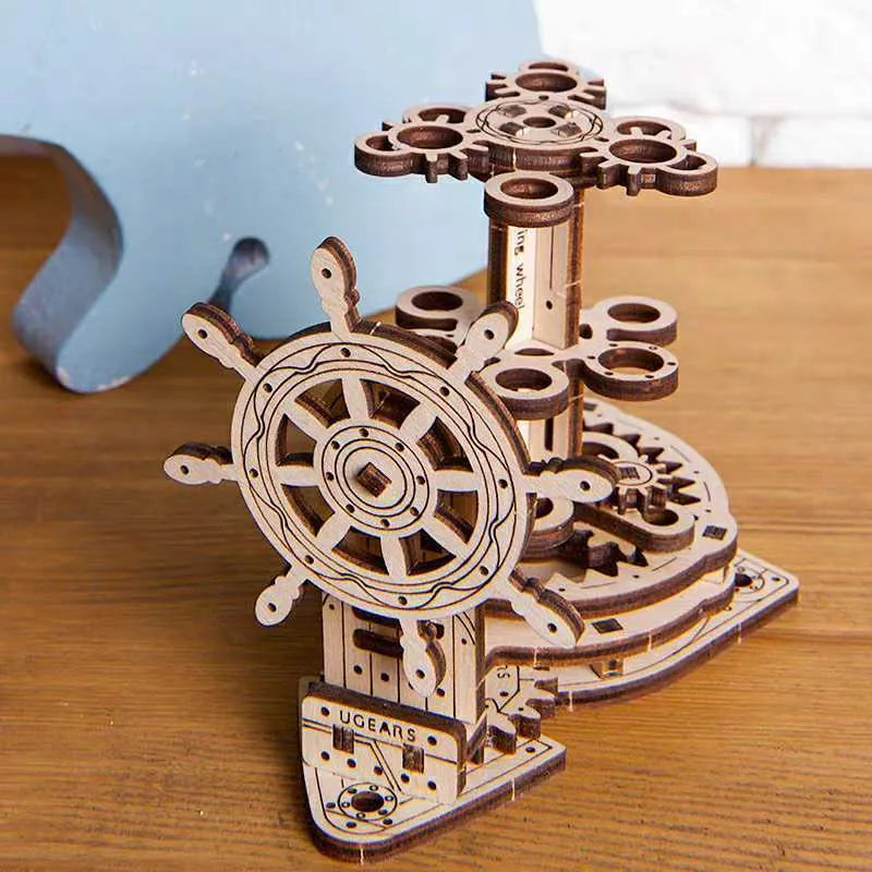 Wooden rotating pen holder model with a steering wheel mechanism on a desk.