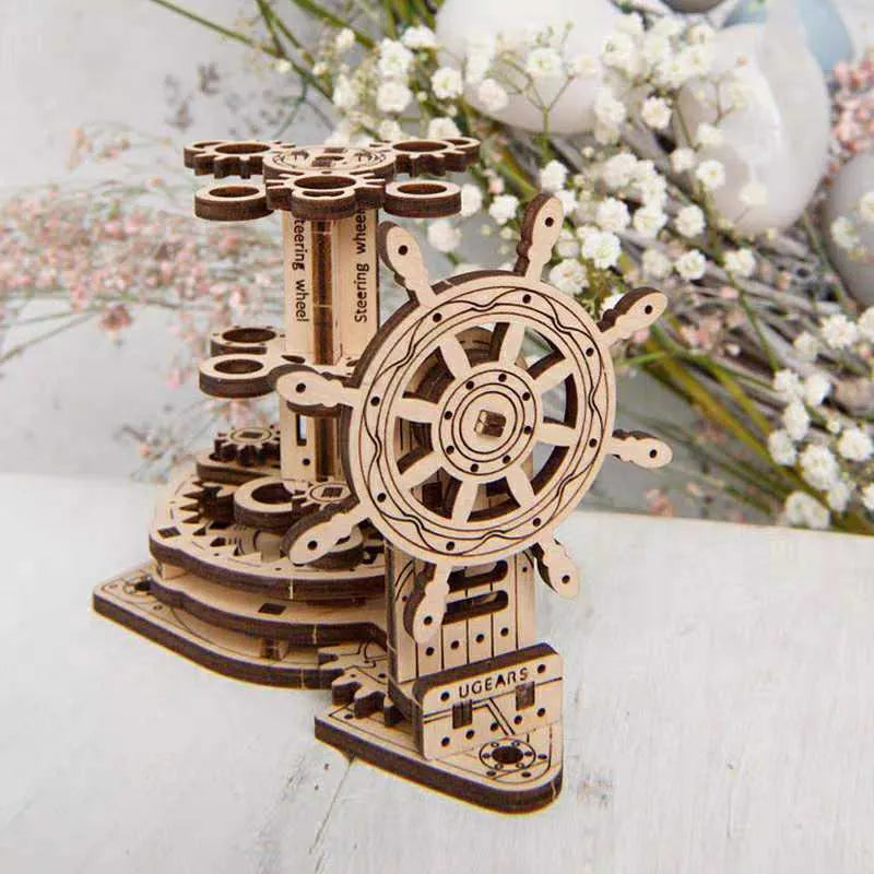Wooden rotating pen holder model with a steering wheel mechanism on a desk.