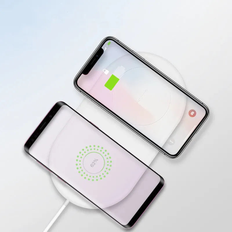 White dual wireless charger for mobile phones showing two devices charging simultaneously