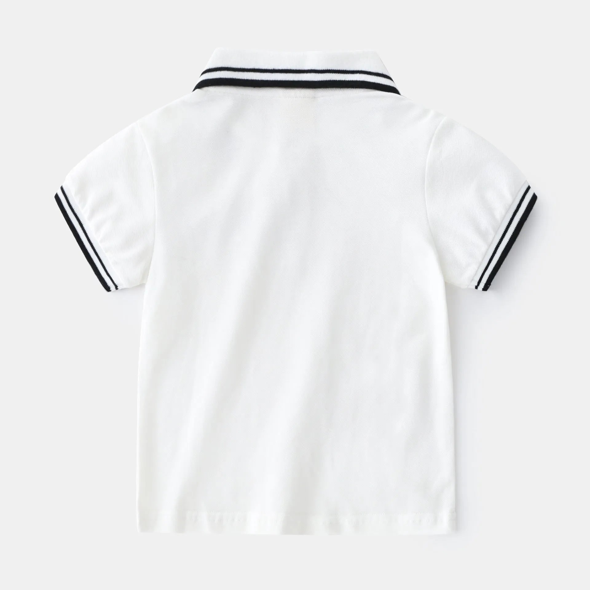 White boys cotton polo shirt with short sleeves and a round neck on a flat lay.