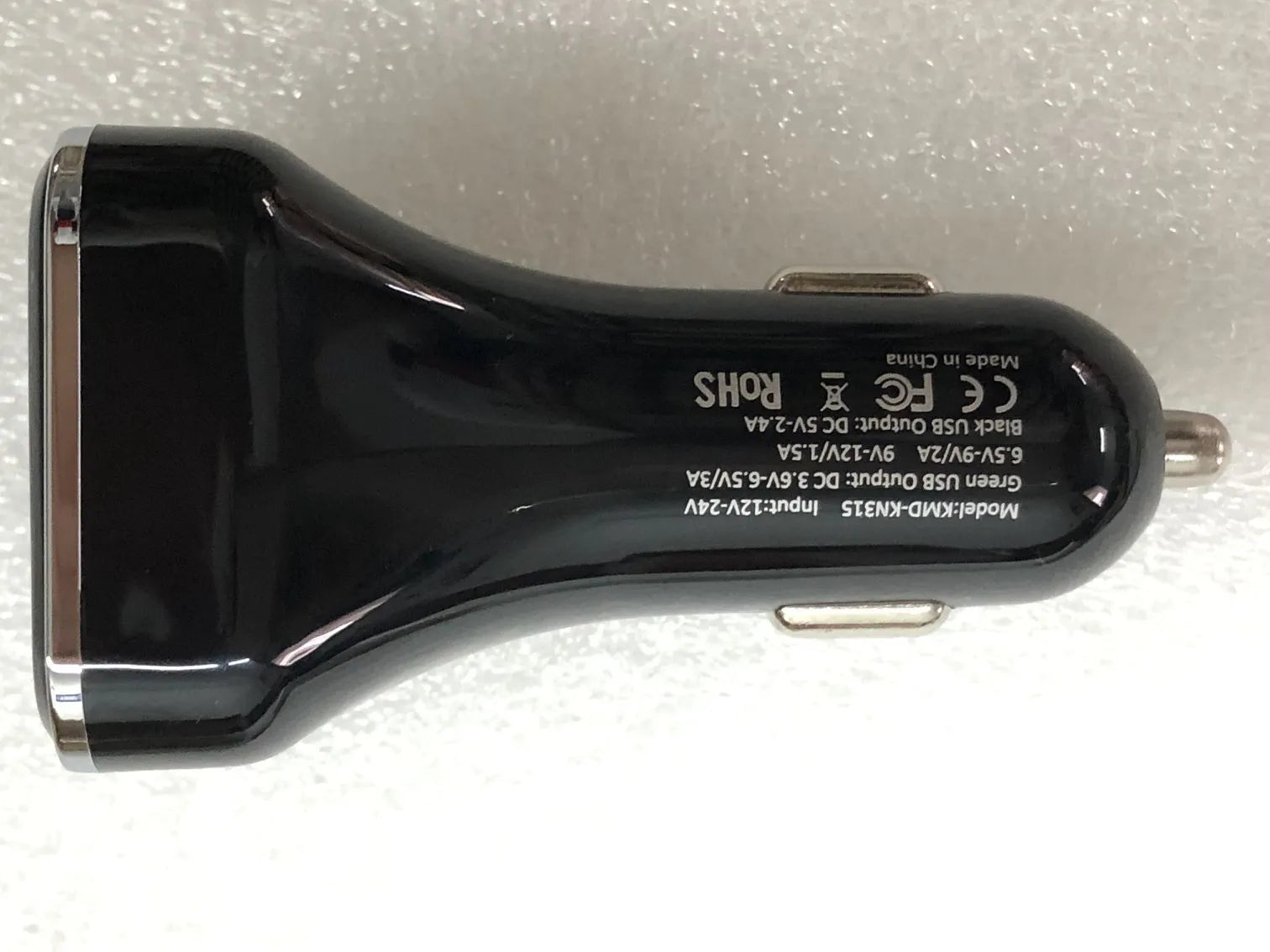 Black car charger with LCD display showing voltage reading, dual USB ports, PC+ABS construction