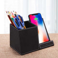 Leather pen holder wireless charger on desk with phone charging and pens organised