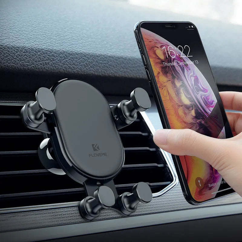 Black gravity car phone holder with 360 rotation mounted on air vent, holding a smartphone