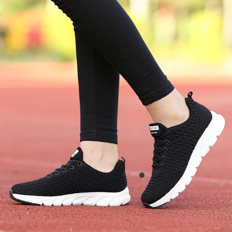 Women's black running shoes with a fly weave upper and wear-resistant outsole.