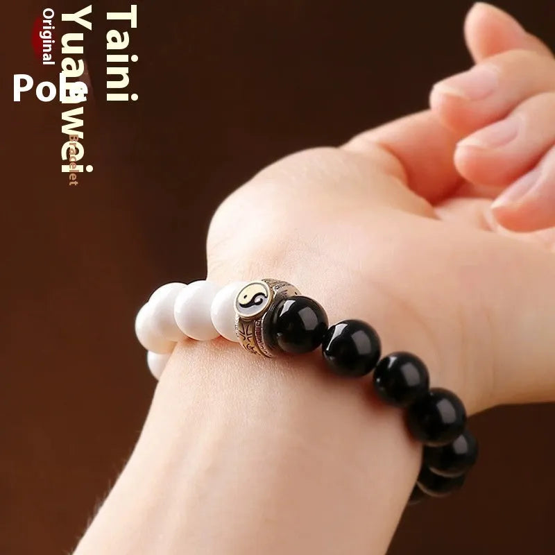 Black and white obsidian geometry-shaped bead bracelet on neutral background