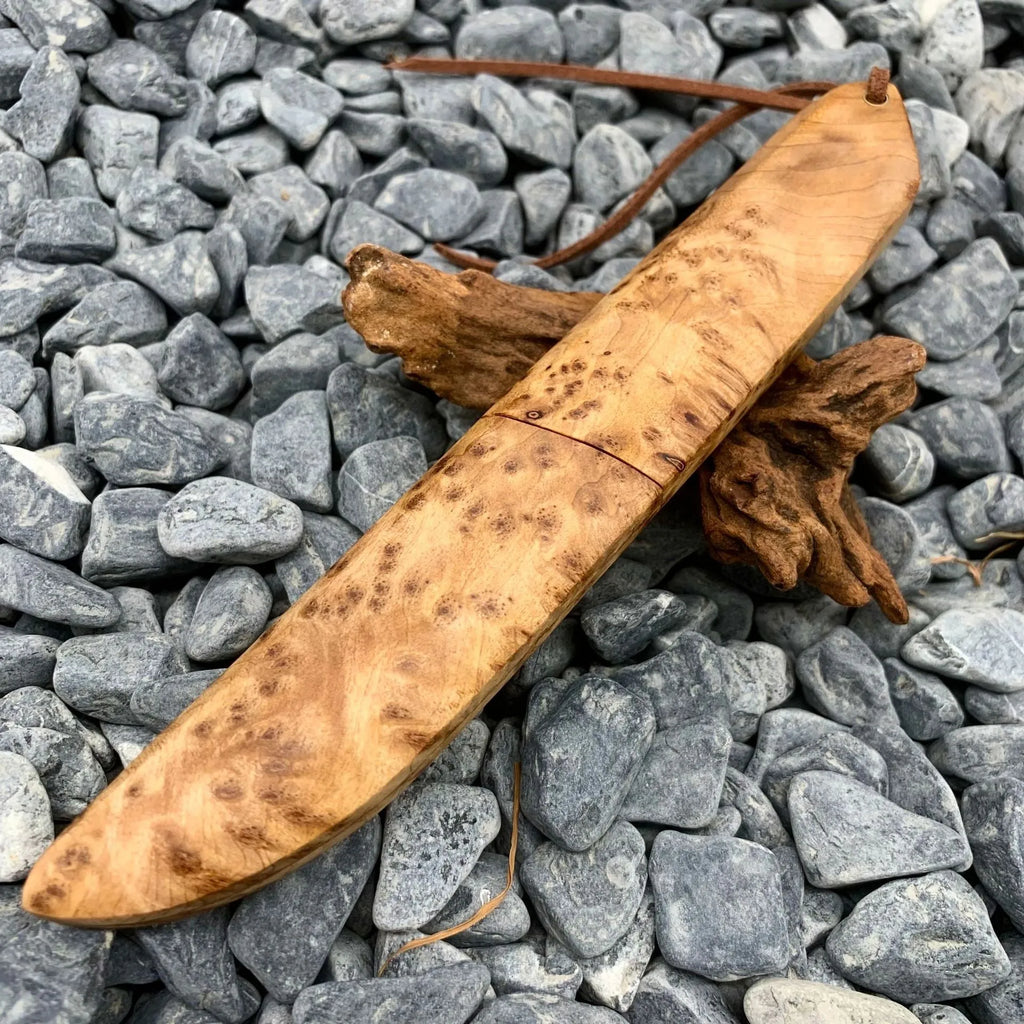 Damascus pattern steel short knife with VG10 steel blade and Thuja wood handle on wooden surface