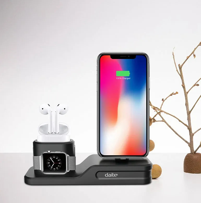 Black 3-in-1 silicone charging base for iPhone, iWatch, and AirPods on a desk