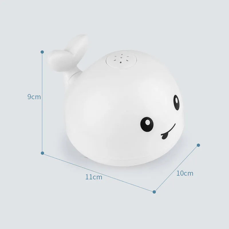 White and blue electric whale bath toy spraying water with lights on a base.