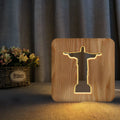 Solid wood hollow night lamp with warm white LED light, USB cable, and button switch on a wooden table