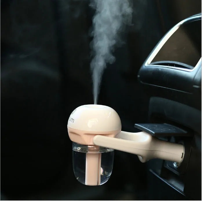 Compact blue car humidifier diffuser with rotating nozzle on a car dashboard