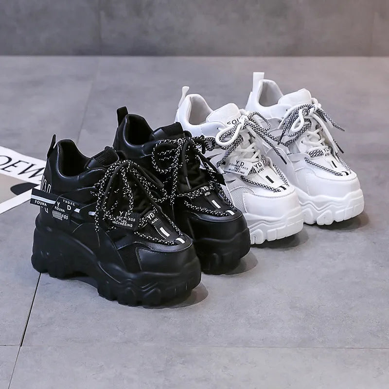 Women's white mesh platform trainers with cross strap and rubber sole showing side profile