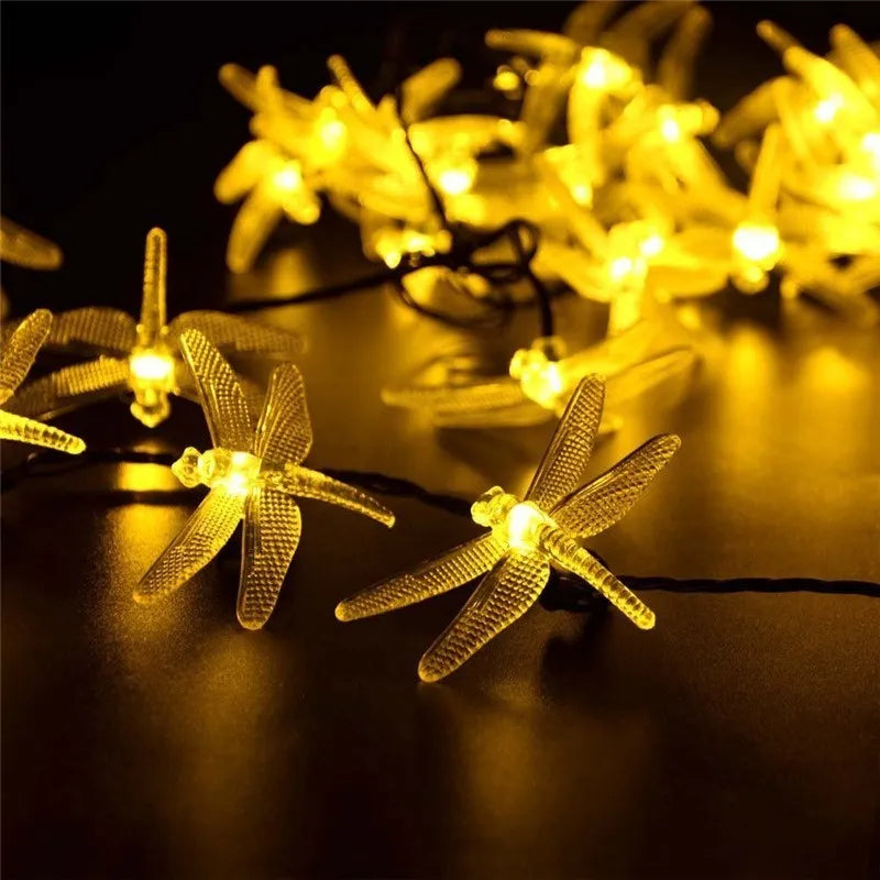 Outdoor solar LED string light with 30 warm white LEDs on 6-metre cable, solar panel with ground spike, and IP65 waterproof rating