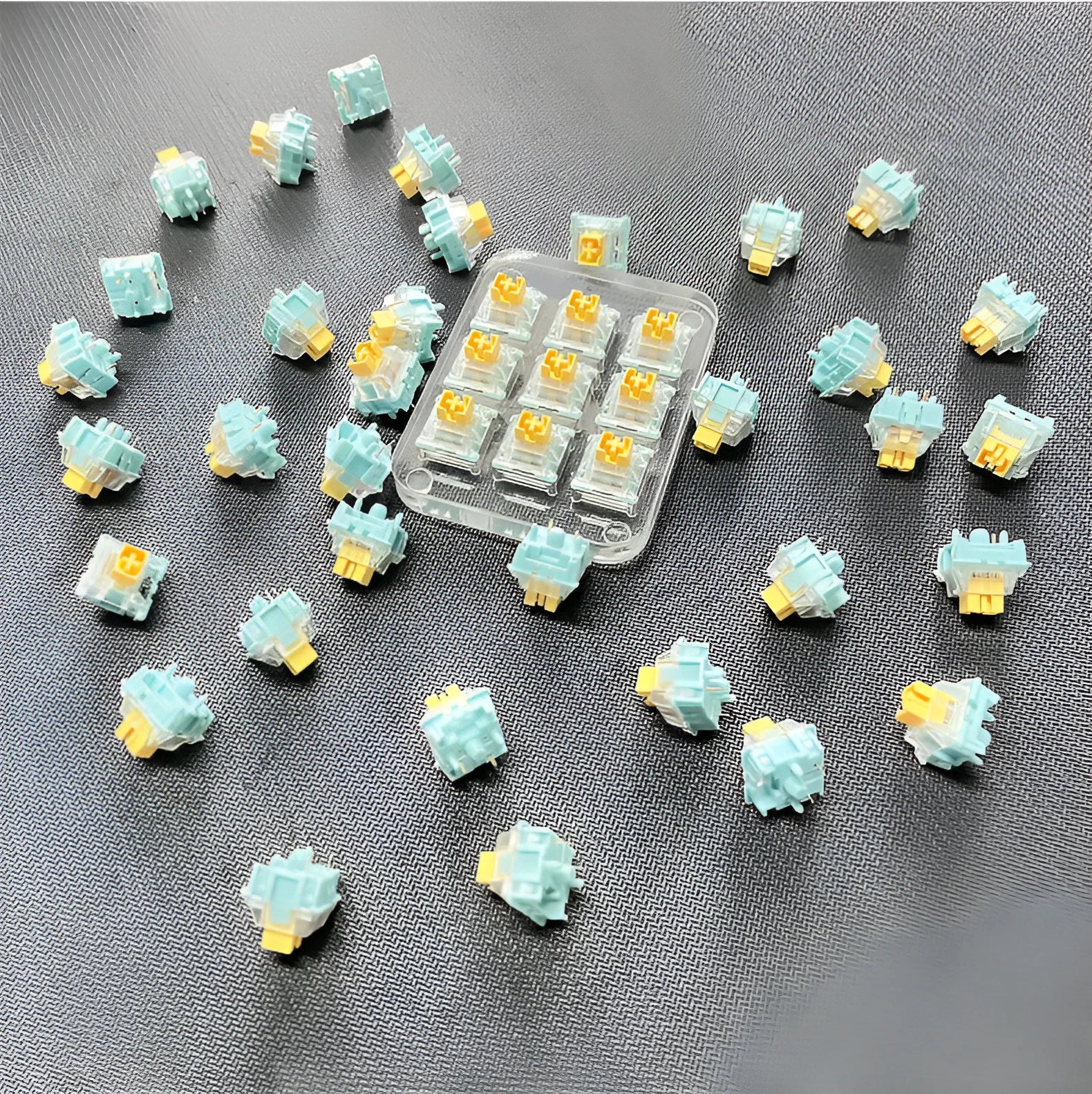 36 clear mechanical keyboard switches with Sea Salt Lemon coloured stems arranged in packaging.