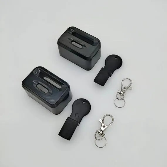 Black plastic ABS seat belt lock catch clamped onto a car seat belt buckle, side view