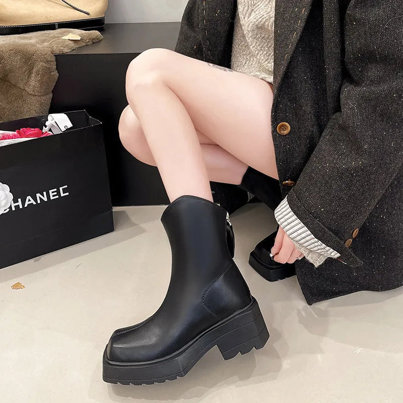 Black women's platform ankle boots with square toe, chunky sole, and rear zip fastening.