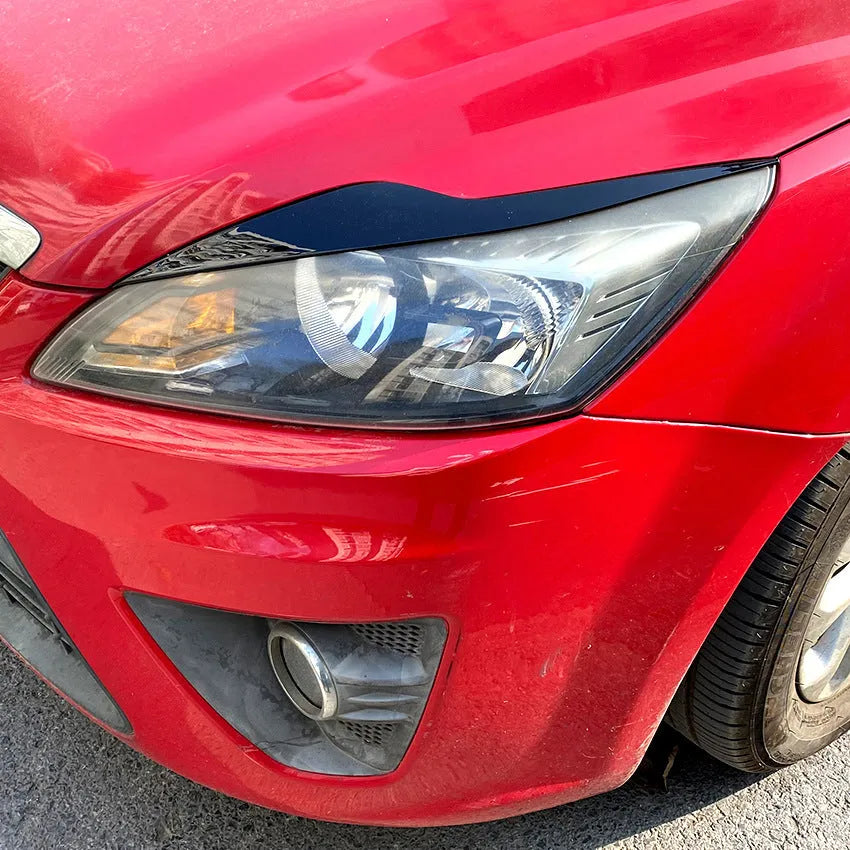 Ford Focus headlight sticker in carbon fiber pattern applied as external eyebrow trim on a car headlight