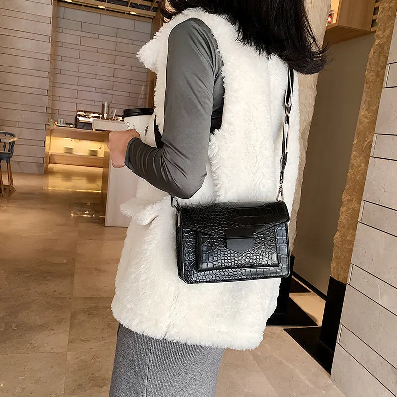 Vintage-style women's crossbody bag in PU leather, shown in black, with adjustable strap.