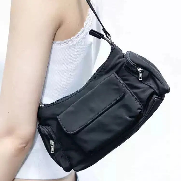 Black women's shoulder bag with double pockets and crossbody strap showing side line detailing
