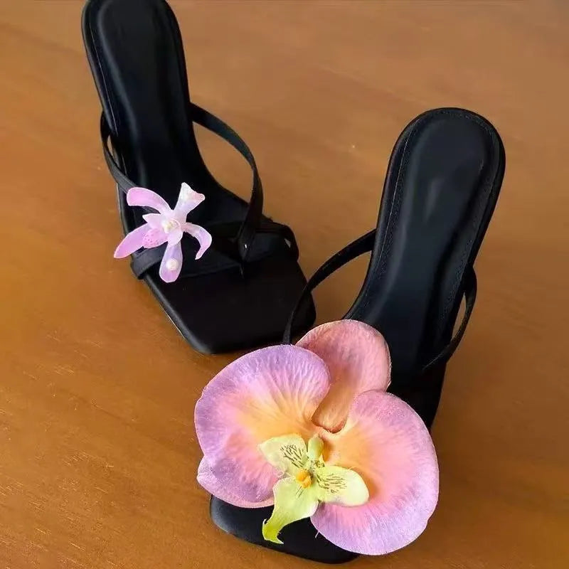 Handmade women's high heel semi-slipper sandals with asymmetric flower detail, calf leather upper, square toe, and EVA sole in black, green, pink, and white
