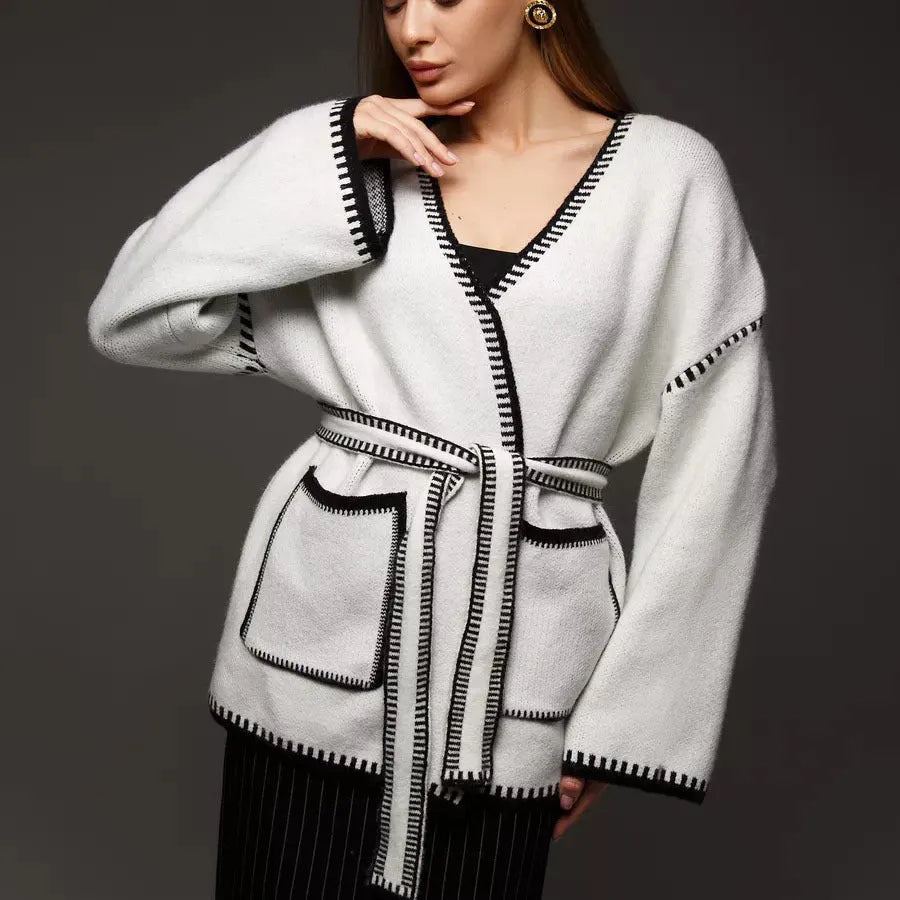 Loose knit camel coloured cardigan sweater with long sleeves on a hanger
