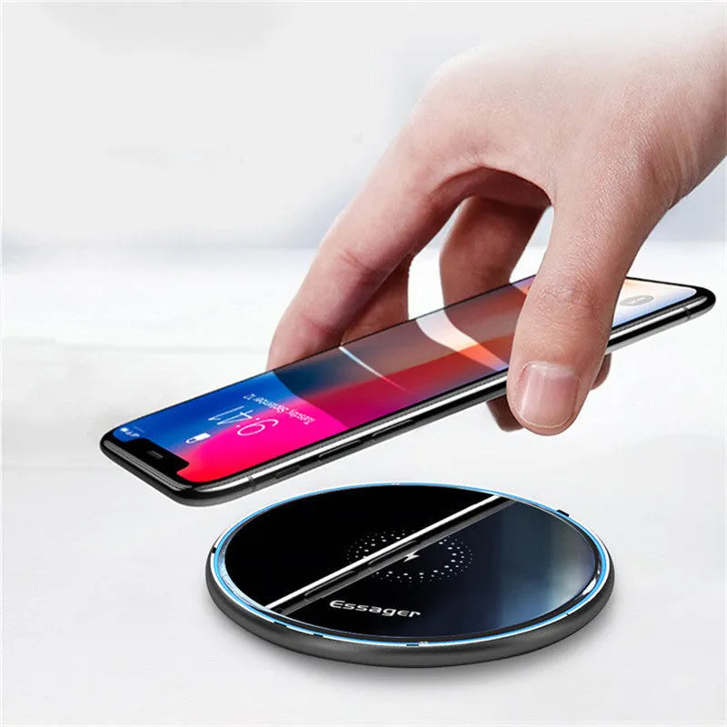 Black or white 15W Qi wireless charging pad on a table with LED light and phone charging.