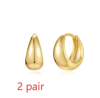 A pair of round, geometric brass earclip earrings with a gold electroplated finish.