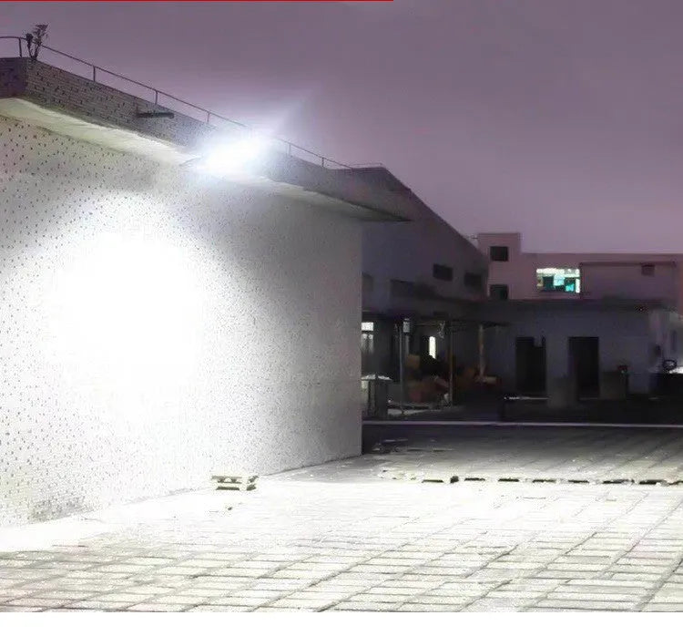 Black outdoor solar-powered motion sensor light mounted on a wall with solar panel visible.