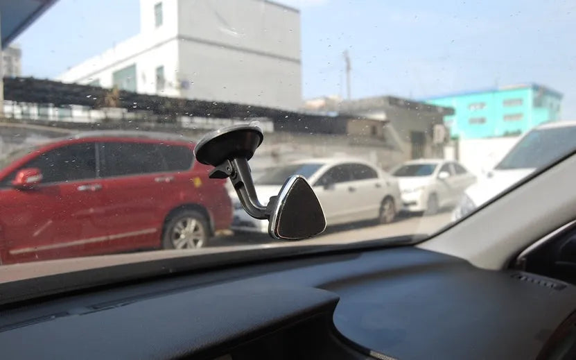 Black magnetic car phone holder with strong magnet mounted on dashboard, holding a smartphone in landscape mode