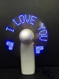 White handheld mini fan displaying blue and red LED 'I love you' pattern, shown next to a ruler for scale.